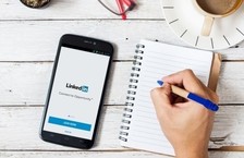linkedin on smartphone with pen and paper