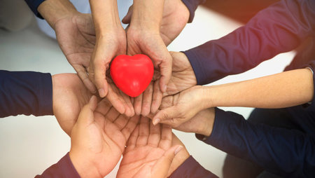 Group of hands holding red heart