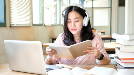 Young woman listening to music while studying