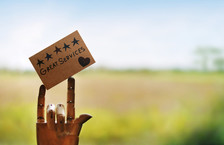 Wooden mannequin hand holding card saying &#39;great services&#39;