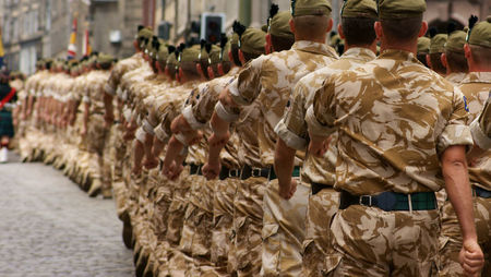 British Army soldiers wearing desert camouflage marching in a public street