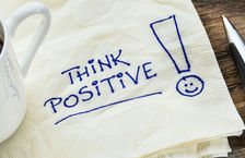 Think positive text written on a tissue with pen 