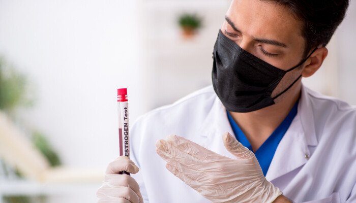 A male biochemist holding a blood sample