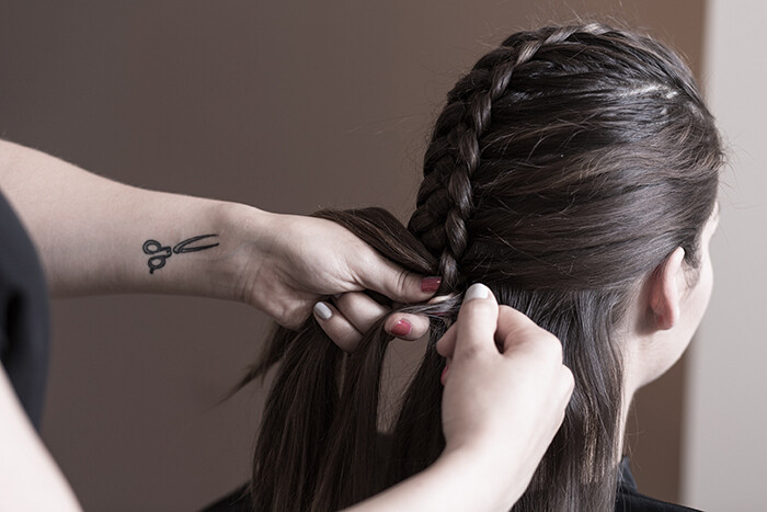 Hairdresser plaiting an actress in film industry