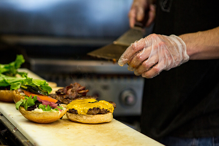 Fast food cook preparing a burger.