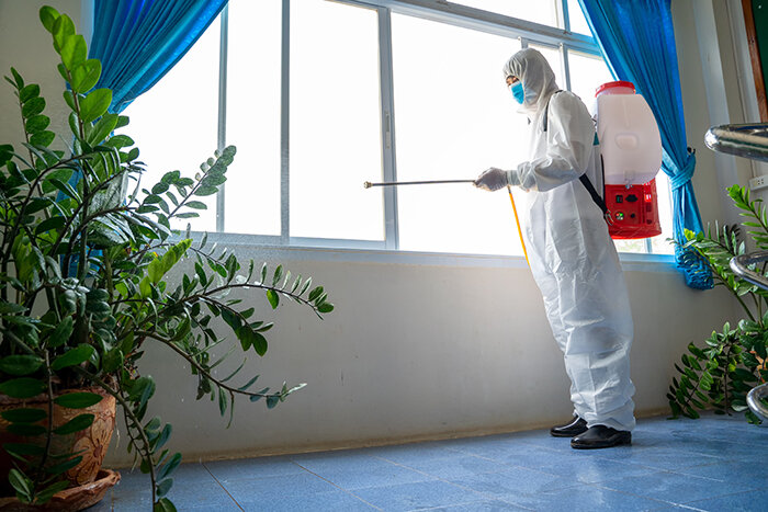 Crime scene cleaner cleaning windows at crime scene.